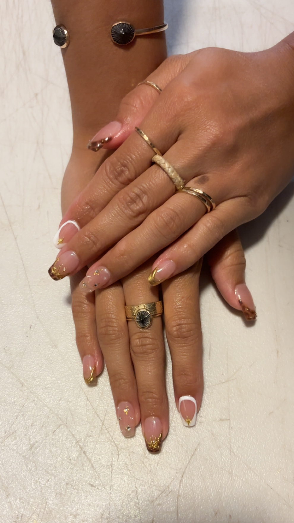 Glossy nude almond nails with white and gold French art by Kulia